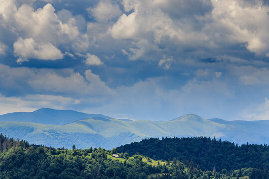 Sun rays breaking through storm clouds over an abandoned shepherd&rsquo;s hut in the Carpathians