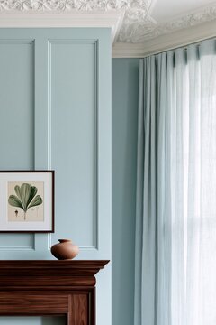 Living room corner featuring a dark walnut mantelpiece, light blue wall with decorative paneling, and a framed botanical print above a ceramic vase
