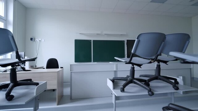 Study room stays quiet with furniture arranged for floor cleaning. Daylight from windows highlights minimalist design of school facility
