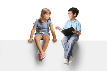 Obraz premium Kids sitting on a blank panel and reading a book