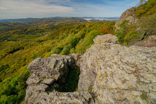 Aerial view of the rocky summit of Sitno in Stiavnicke Vrchy surrounded by vibrant autumn forests and rolling hills in Ilija, Banska Bystrica Regio, Slovakia.