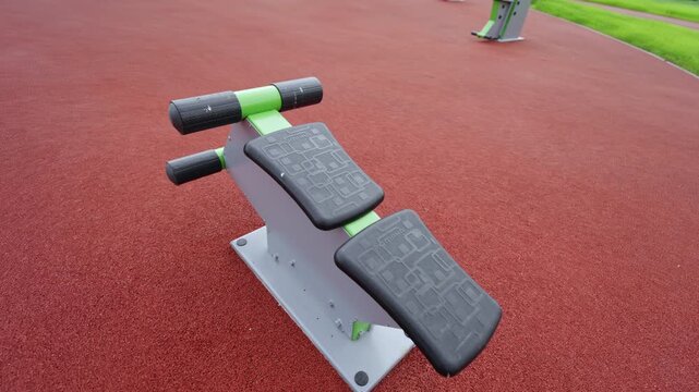 Metal fitness station features green accents and black pads. Professional workout zone offers ideal conditions for daily athletics