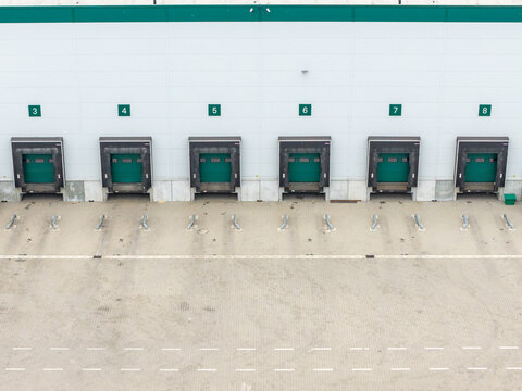 Aerial view of a logistics warehouse with numbered loading bays and green dock shelters in Warszawa, Wojewodztwo mazowieckie, Poland.