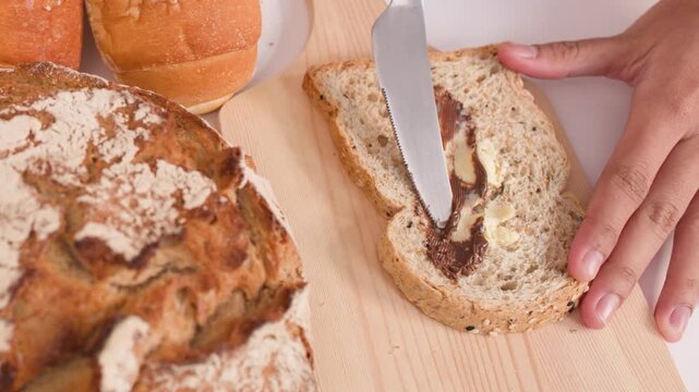 Spreading Peanut Butter and Butter on Multigrain Bread Slice
