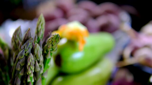 Courgettes young zucchini with flowers on the market young zucchini at the market, a yellow zucchini flower adorns the farmer window, next to asparagus, beets in the background