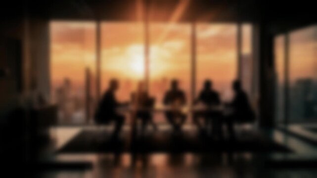 Blurred business meeting silhouetted against a sunset city skyline. Corporate discussion, leadership, strategic planning and teamwork in a modern conference room.