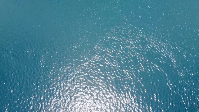 Aerial view flying above shimmering ocean water in coral triangle region of Timor-Leste in Southeast Asia