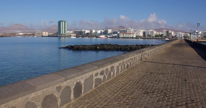 Wide shot looking down Calle Punta de la Lagarta, with Arrecife in background
