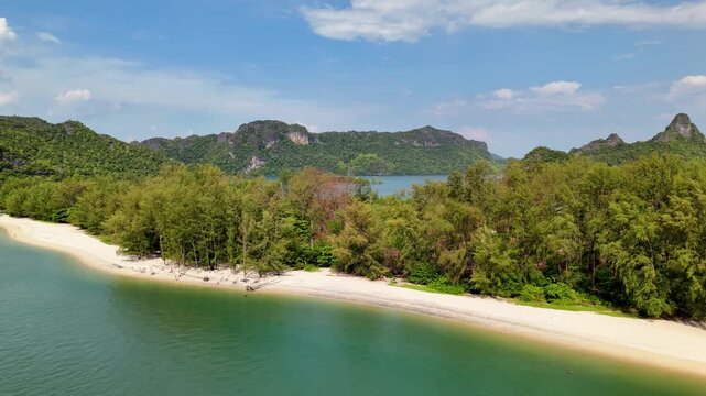 Stunning 4K drone footage gliding over the pristine white sands and vivid turquoise waters of Tanjung Rhu Beach, one of Langkawi's most beautiful and secluded coastal gems, Malaysia.