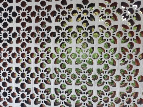 Close up of the uniquely patterned white concrete roster ventilation hole design for building exterior decoration