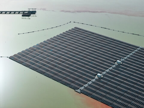 Aerial view of a large floating solar farm array on a calm lake surface in Dulmen, North Rhine-Westphalia, Germany.