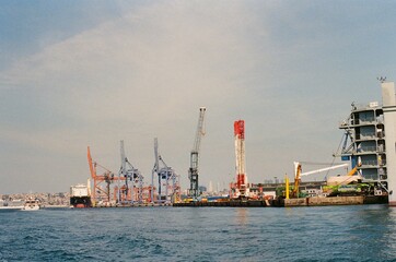 Fototapeta premium Industrial Port with Cargo Ships and Cranes on the Waterfront 