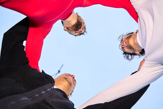 Group of young men huddling supporting each other