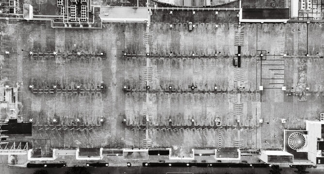 Aerial view of a large rooftop parking lot with marked spaces, ventilation units, and structural details in Santo Domingo, Dominican Republic.