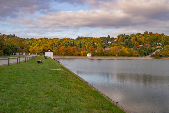 View of Velka Richnava lake with vibrant autumn foliage and grassy banks Stiavnicke Bane, Banska Bystrica Region, Slovakia.
