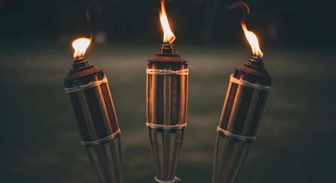 Three Tiki Torches Burning Brightly in the Evening Darkness.