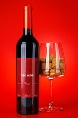 Fototapeta premium Red wine bottle mockup on red background