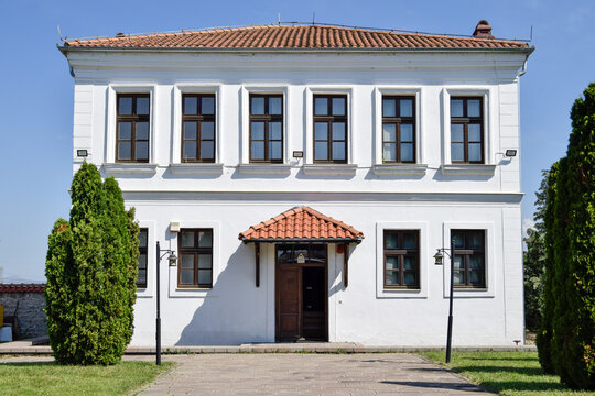 View of the historic Emin Gjiku Ethnological Museum with its white facade, tiled roof, and symmetrical windows in Pristina, Kosovo.