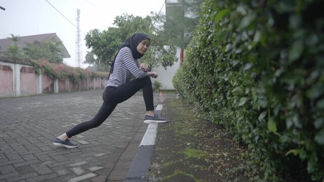 Muslim Woman Stretching Calf and Hip Flexor Before Running