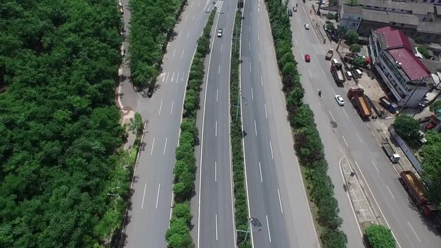 Aerial view of multi-lane expressway lined with trees and passing vehicles