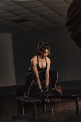 Naklejka premium Fit young woman trains with a kettlebell, showcasing power and endurance in a stylish fitness studio. The gym environment highlights her dedication to a healthy and active lifestyle