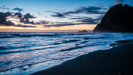 Obraz premium Blue Hour Beach with Sea Cliff and Horizon Glow
