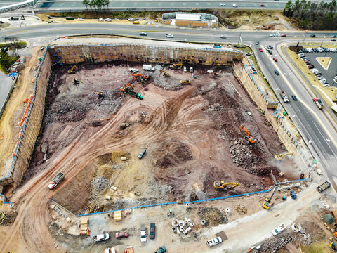 Reston, United States - 12 March 2019: Aerial view of a large construction site with heavy machinery, excavators, and earthmoving equipment in a cleared urban area.