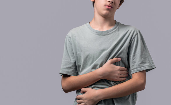 Stomach pain. Child having terrible pain in stomach. Diarrhea or gastroenteritis health problem. Teen boy with stomachache
