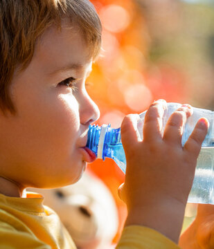 Thirsty child little boy baby drink water. Child with a bottle of mineral water. Boy bottle of water