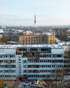 Riga, Latvia - 02 January 2026: Aerial view of a damaged residential building on Bauskas iela with the Riga TV Tower in the background under a winter sky.