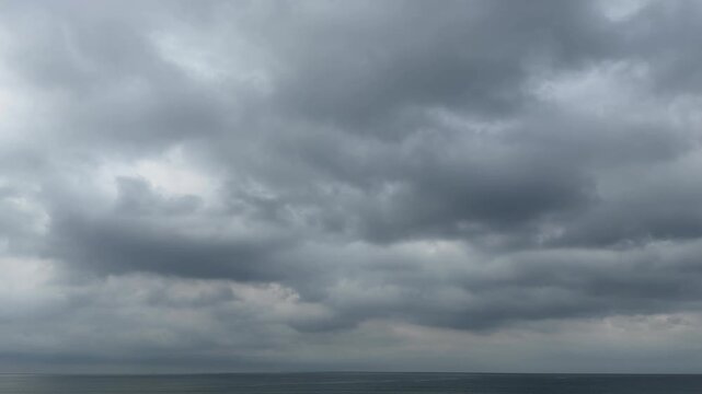 重厚な雲に覆われた曇り空と穏やかな水平線