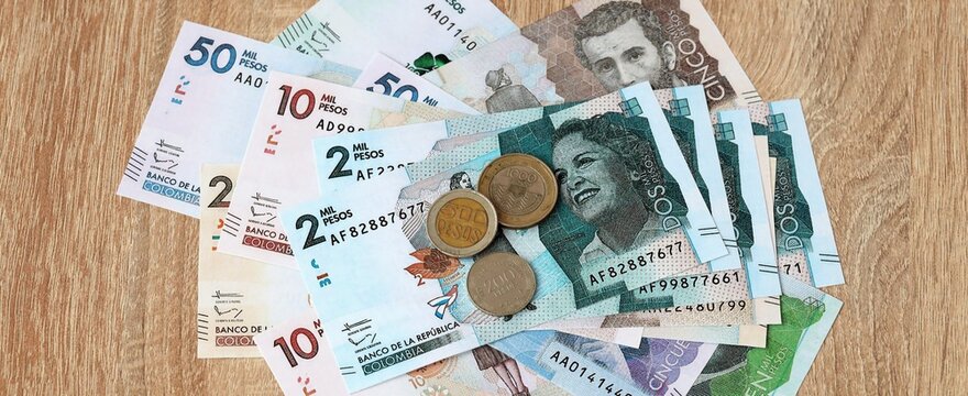 Colombian peso money bills and coins on table. Colombia cash of COP currency close up