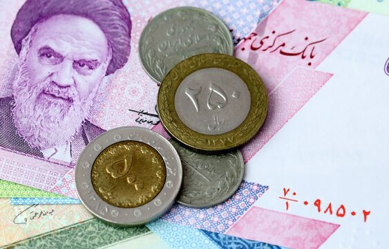 Iranian rial money bills and coins on table. Iran cash of IRR currency close up