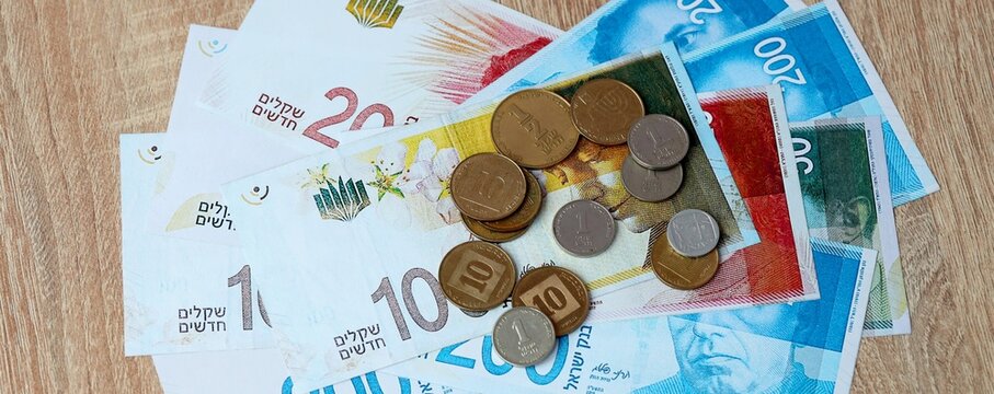 Israeli shekel money bills and coins on table. Israel cash of ILS currency close up