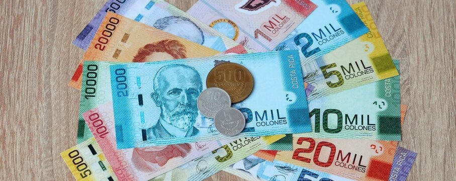Costa Rican colon money bills and coins on table. Costa Rica cash of CRC currency close up