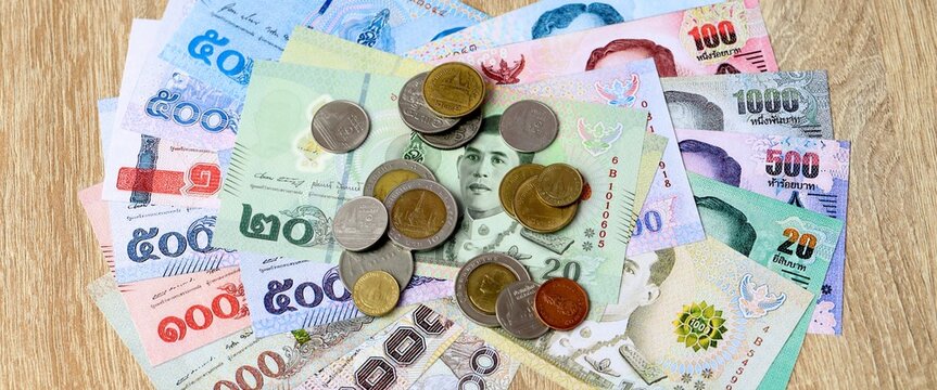 Thai baht money bills and coins on table. Thailand cash of THB currency close up