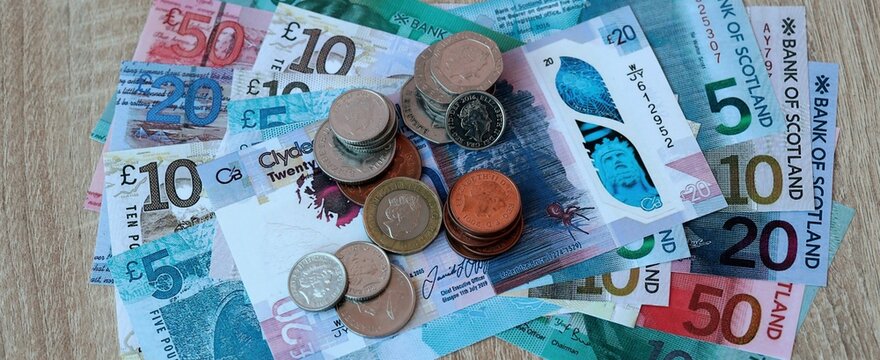 Scottish pound money bills and coins on table. Scotland cash of GBP currency close up