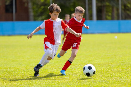Young Goalkeeper Holding Ball: Youth Soccer Player in Green Uniform Preparing for Goal Kick