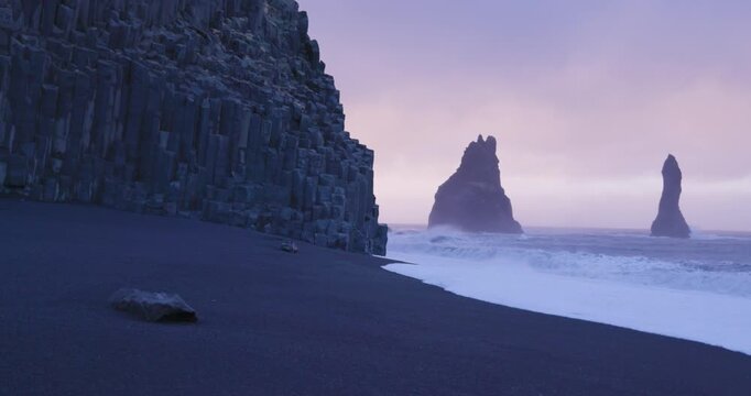 View of the basalt columns and sea stacks at Reynisfjara black sand beach in Iceland.