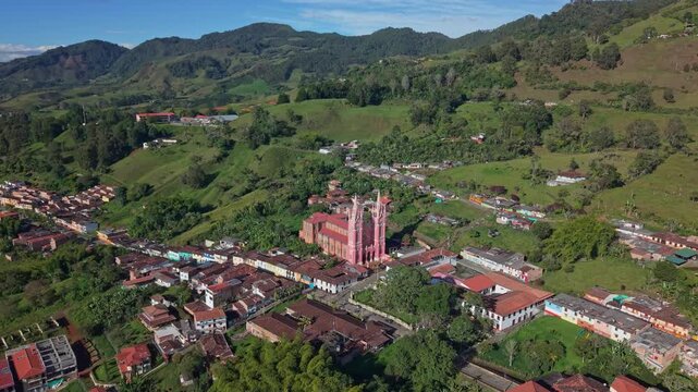 Aerial view of Jerico town center with colorful buildings and large church, lush hills