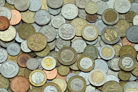 Big pile of coins from different money currencies. Treasure and numismatics concept