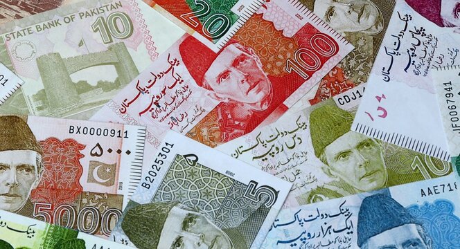 Pakistani rupee money bills in pile on table. Pakistan PKR currency cash close up