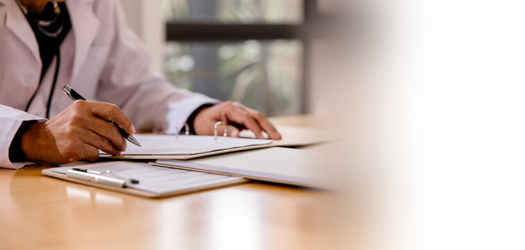 Senior doctor reviewing signing medical documents in a healthcare office. completing patient records, clinical paperwork, administration, diagnosis healthcare management.