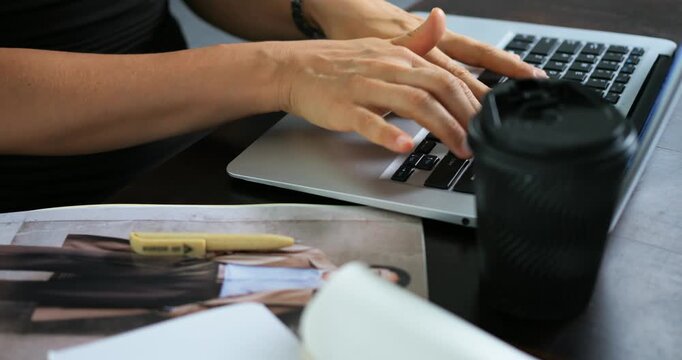 Hands type quickly. Closeup of hands swiftly typing on computer with coffee nearby. Focused hands rapidly inputting on laptop keyboard amidst coffee and minimalist workspace accessories