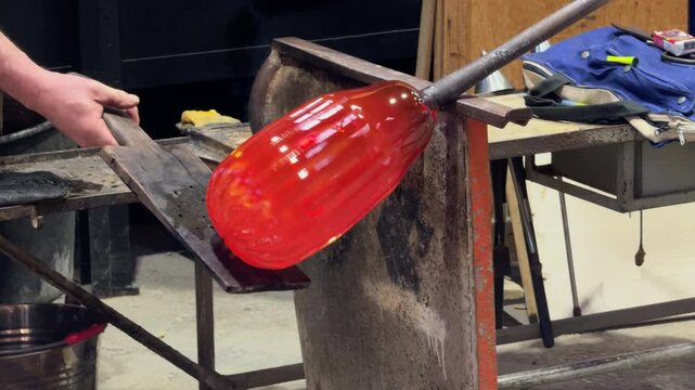 Artisan Shaping Molten Glass in a Murano Workshop
