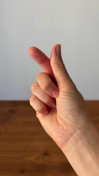 Close-up of a hand forming a heart gesture with fingers. Symbol of love, affection, friendship and positive emotions, widely used in social media and modern communication.