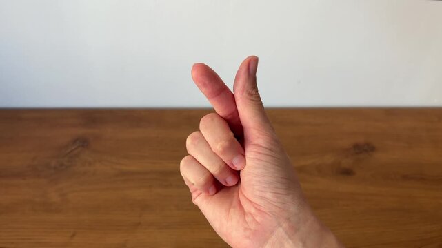 Close-up of a hand forming a heart gesture with fingers. Symbol of love, affection, friendship and positive emotions, widely used in social media and modern communication.