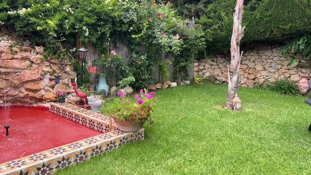 Paneo de jard&iacute;n mediterr&aacute;neo con tumbonas, fuente y hamaca