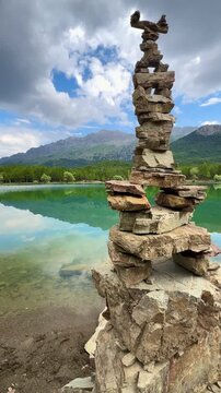 Serene Lake Reflections with Balanced Zen Stones and Forest Background