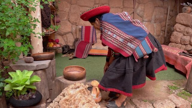 Peruvian woman in traditional clothes processing alpaca wool for textiles